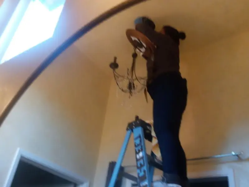 Electrician installing a chandelier in a Martinez residence